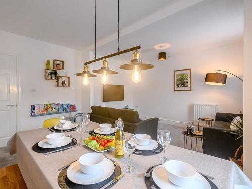 a dining room with a table with plates and glasses at St James By the Quay in Ilfracombe