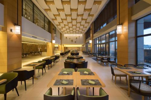a restaurant with tables and chairs and windows at Holiday Inn Kunshan Huaqiao by IHG in Kunshan