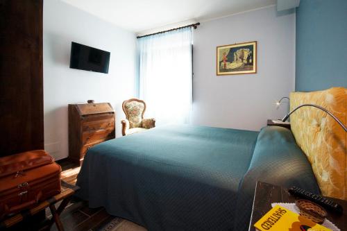 a bedroom with a bed and a dresser and a window at Santa Maria Degli Ancillotti in Petrignano