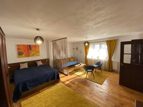 a bedroom with a bed and a desk and a chair at SIM House & Barn in Săcele