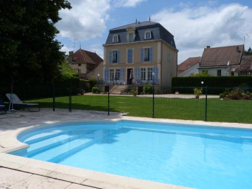 een groot blauw zwembad voor een huis bij Hôtel Restaurant du Cheval Blanc in Saint-Boil