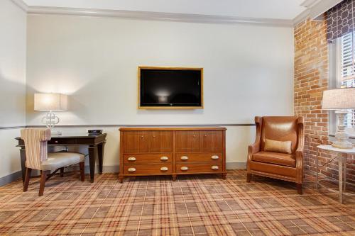 ニューオーリンズにあるThe Brakeman Hotelの机と壁にテレビが掛かっている部屋