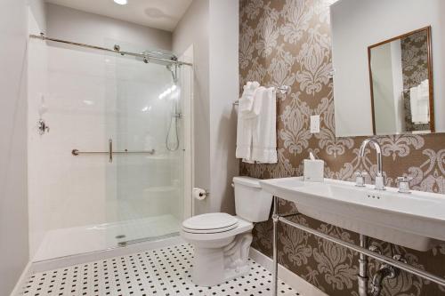 a bathroom with a toilet and a sink and a shower at The Brakeman Hotel in New Orleans