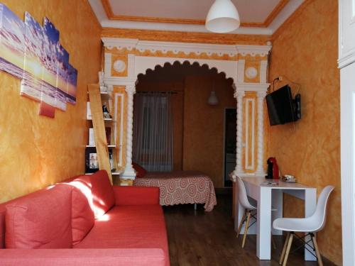 salon z czerwoną kanapą i stołem w obiekcie Hospedaje Menendez Pelayo w mieście Santander