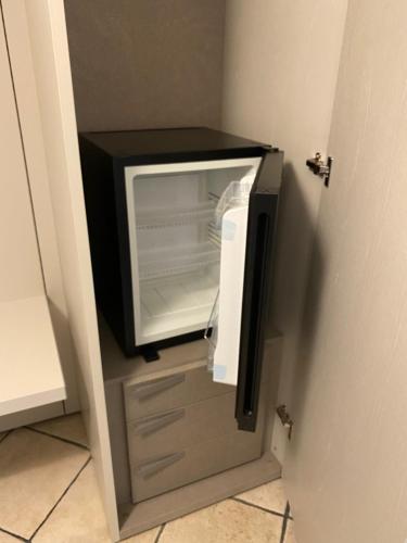 a small refrigerator with its door open in a room at B&B ALDA in Levanto
