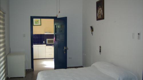 a bedroom with a bed and a blue door at Hacienda San Jose Poniente Blue House in Hoctún