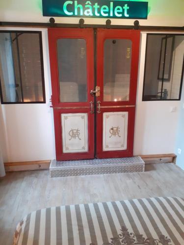 a red double doors of a building with a sign at ancienne maison des templiers in Gouillons