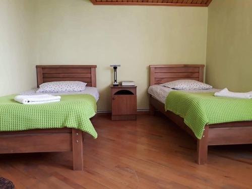 two beds with green sheets in a room at safari house in Tbilisi City