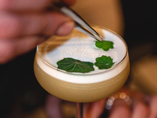 a person is sprinkling whipped cream on a drink at Dakota Leeds in Leeds