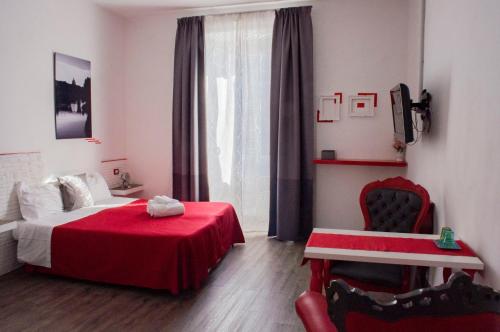 1 dormitorio con cama roja y silla roja en Relais Cola Di Rienzo, en Roma