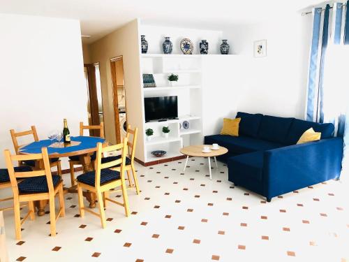 een woonkamer met een blauwe bank en een tafel bij La Mata Beach Resort in La Mata