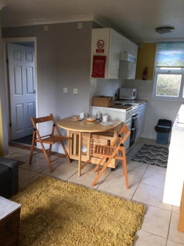 a kitchen with a table and chairs in a room at 8 Sandy Bottom Sandown Bay Holiday Park, reduced ferry, please contact us in Sandown