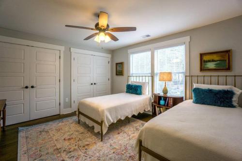 a bedroom with two beds and a ceiling fan at Beaufort Cottage in Pigeon Point Near Downtown Beaufort and Paris Island in Beaufort