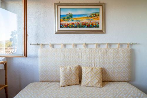 a bed in a room with a picture on the wall at Smeralda in Cugnana