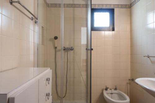 een badkamer met een douche, een toilet en een wastafel bij Pedras Del Rei II in Tavira
