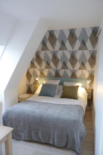 een slaapkamer met een bed met een geometrische muur bij Studio -vue mer résidence Grand Cap in Villers-sur-Mer