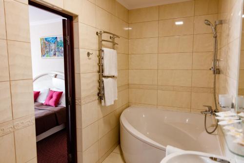 a bathroom with a bath tub and a sink at Argo in Lviv