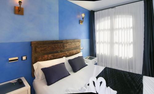 a bedroom with a large bed with blue walls at Posada la Leyenda in Santillana del Mar