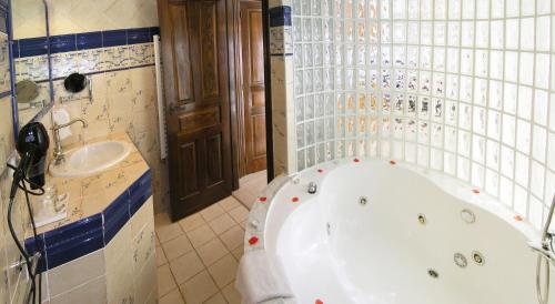 a bathroom with a bath tub and a sink at Posada la Leyenda in Santillana del Mar