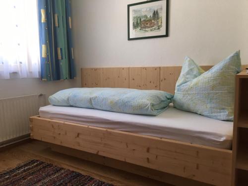 a wooden bed with two pillows on top of it at Mitterbergerhof in Wiesen
