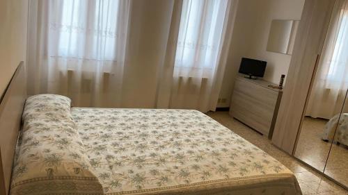 a bedroom with a bed and a tv and curtains at Appartamento Damiana in Venice