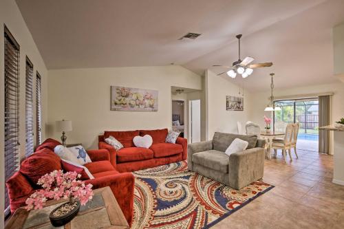 ein Wohnzimmer mit einem roten Sofa und einem Stuhl in der Unterkunft The Pelican Escape with Lanai about 3 Mi to Downtown! in Cape Coral