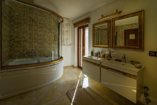 a bathroom with a tub and a sink and a mirror at Kazdaglari Karye M&uuml;ze Hotel in Kucukkuyu