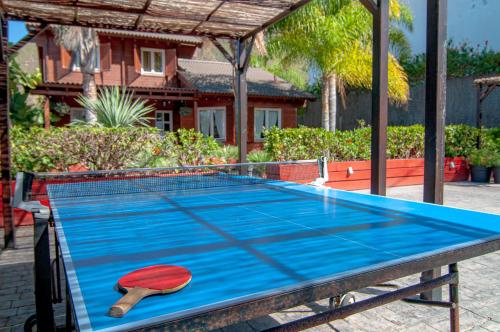 a ping pong table with a paddle on top of it at El Rincón Del Huroncillo in Tejina
