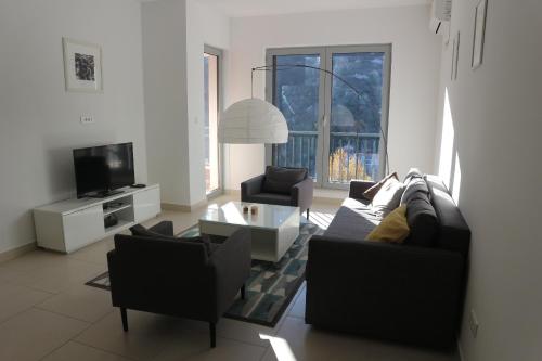 a living room with a couch and chairs and a tv at Lavender Bay Apartments D3 or D5 I by Andreas Crivellaro in Donji Morinj