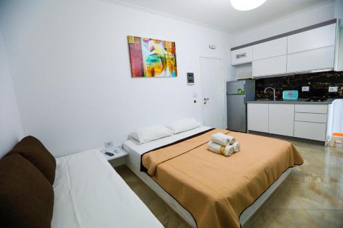 a white bedroom with a bed and a kitchen at Vila Enxhi in Ksamil