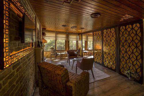 a living room with a couch and a table with chairs at Kazdaglari Karye Müze Hotel in Kucukkuyu
