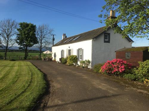 a white house on the side of a road at South Doll Farm Cottage in Airth