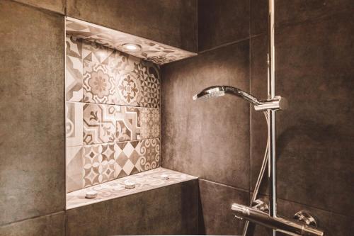 La salle de bains est pourvue d'une douche avec un robinet et un lavabo. dans l'établissement HDC Nivelles Grand-Place, à Nivelles