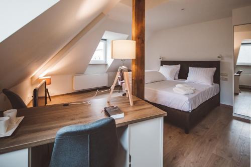 Schlafzimmer mit einem Bett und einem Schreibtisch mit einer Kamera in der Unterkunft HDC Nivelles Grand-Place in Nivelles