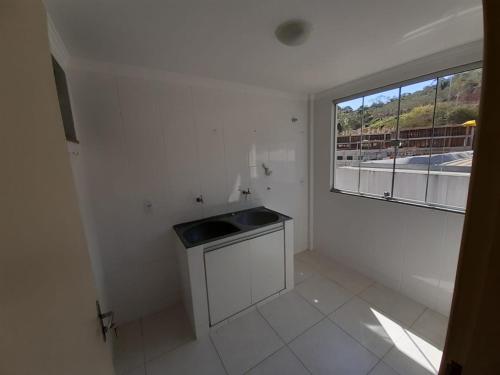 Dieses weiße Zimmer verfügt über ein Waschbecken und ein Fenster. in der Unterkunft casa/apartamento centro Santa Teresa-ES in Santa Teresa