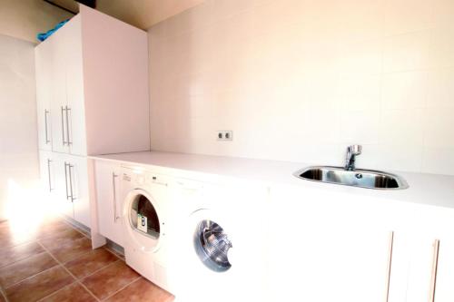 a kitchen with a washing machine and a sink at Mallorca Villa Bon Aire Son Bernat in Llubí