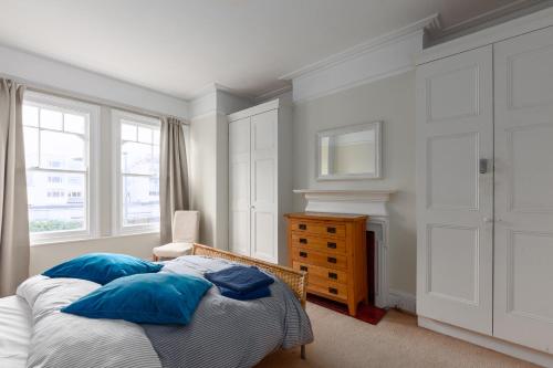 a bedroom with a bed with blue pillows at Wix's Lane in London
