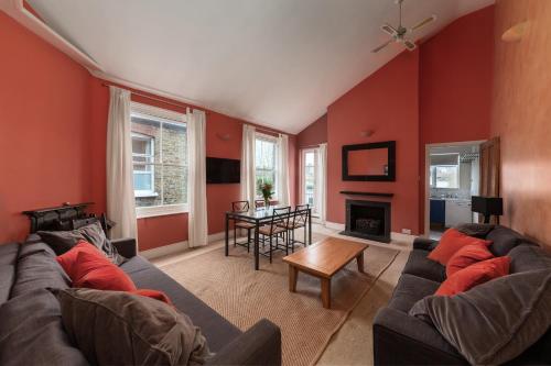 a living room with red walls and a couch and a table at Wix's Lane in London