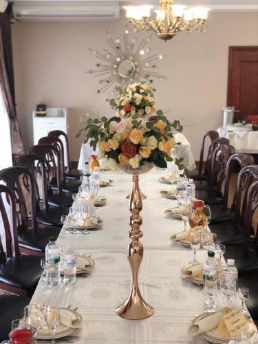 a long table with a vase of flowers on it at Старый Бастион in Bender