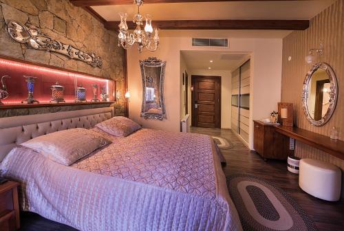 a bedroom with a large bed and a mirror at Kazdaglari Karye Müze Hotel in Kucukkuyu