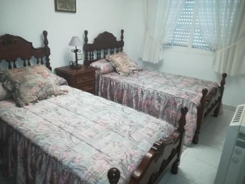 a bedroom with two beds and a window at Piso de Verano in O Grove
