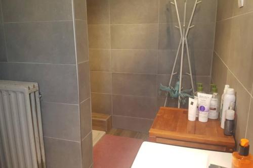 a bathroom with bottles ofodorizers on a wooden table at Maison Rochefort quartier Montrival in Rochefort