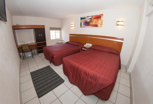 Habitación de hotel con 2 camas y mesa en Hotel Interforum, en León