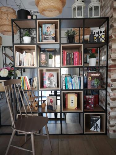 a book shelf filled with books and a chair at Tulipanowy Gościniec in Jantar