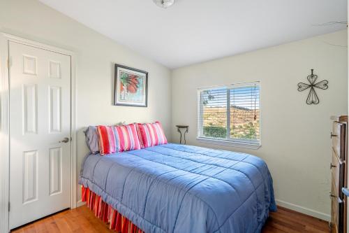 Un dormitorio con una cama azul y una ventana en Sirena Vineyard Resort - 3 Bedroom guest house, en Paso Robles