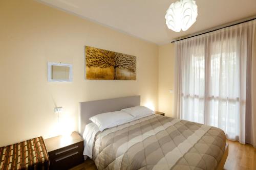 ein Schlafzimmer mit einem Bett und einem großen Fenster in der Unterkunft Appartamento Essenza in Sirmione