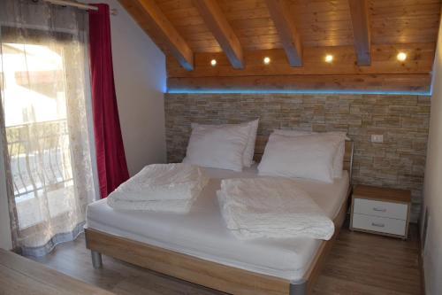 a bed in a room with a brick wall at Casa Vacanza CADORNA RESIDENCE in Tarvisio