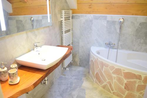 W łazience znajduje się umywalka i wanna. w obiekcie Casa Vacanza CADORNA RESIDENCE w mieście Tarvisio