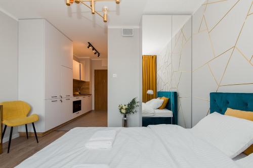 sypialnia z dużym białym łóżkiem i kuchnią w obiekcie Warsaw To Be - Golden Apartment w Warszawie