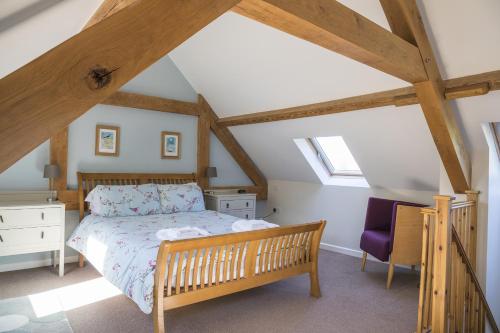 ein Schlafzimmer mit einem Bett und einem Stuhl auf einem Dachboden in der Unterkunft Finest Retreats - 1 Bed Llangollen Cottage - Sleeps 2 in Llangollen